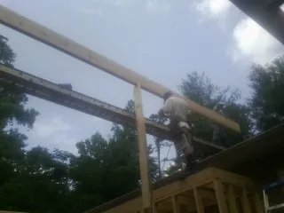 Carpenter setting a ridge beam over a new addition frame — Ice Dam Removal by Roofing Brothers in Jetersville