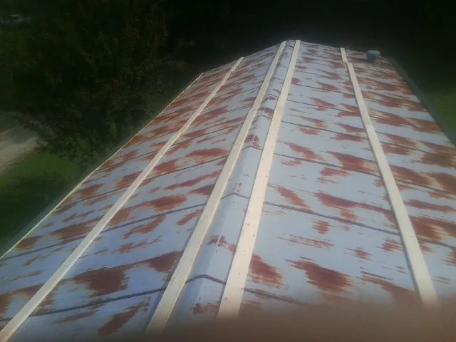 Rusted metal roof panels with new wood purlins before replacement — Storm Damage Roof Repair in Jetersville by Roofing Brothers