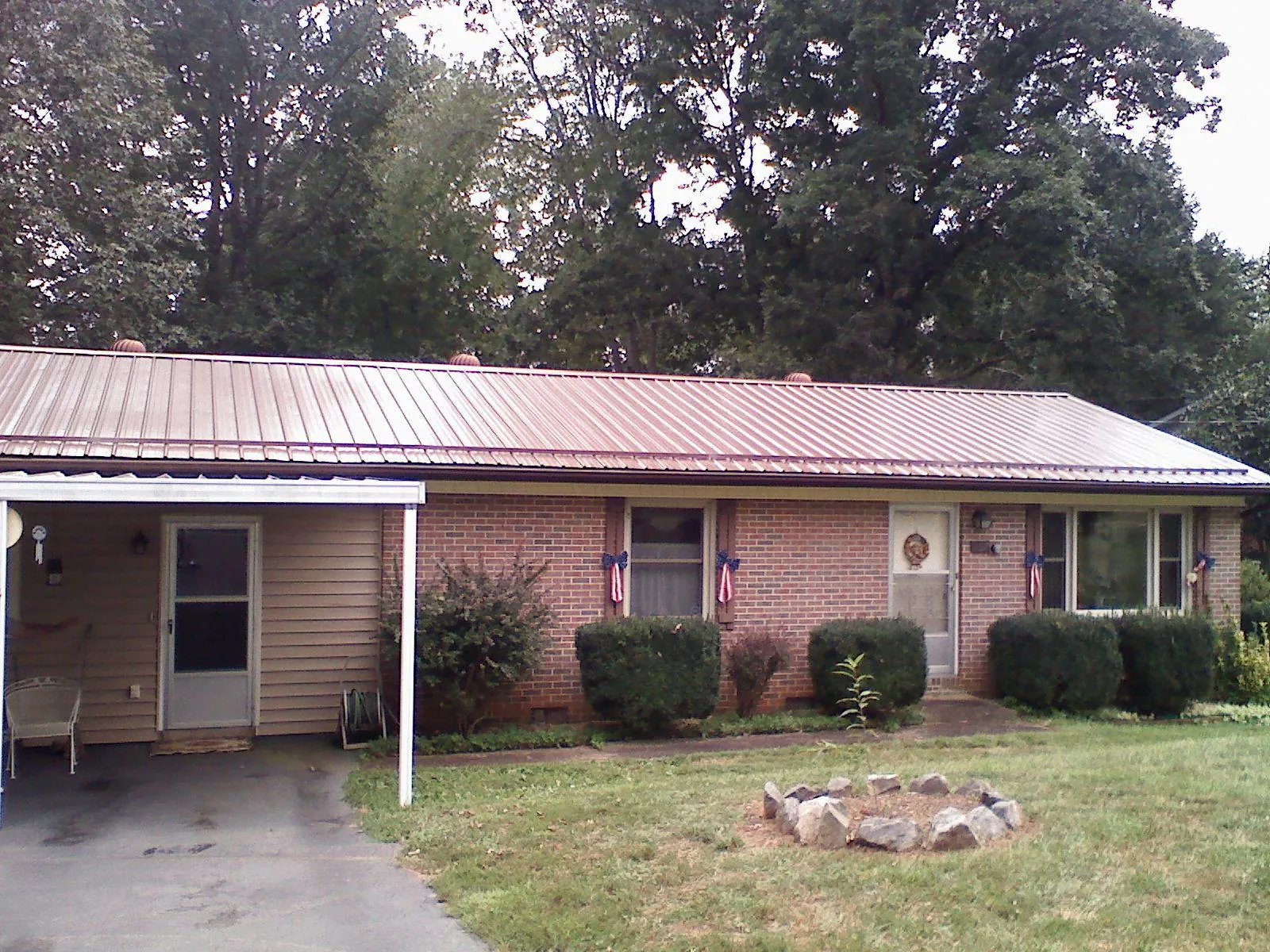 Bronze metal roof and carport on a brick ranch home — Roof Repair work by our crew in Jetersville